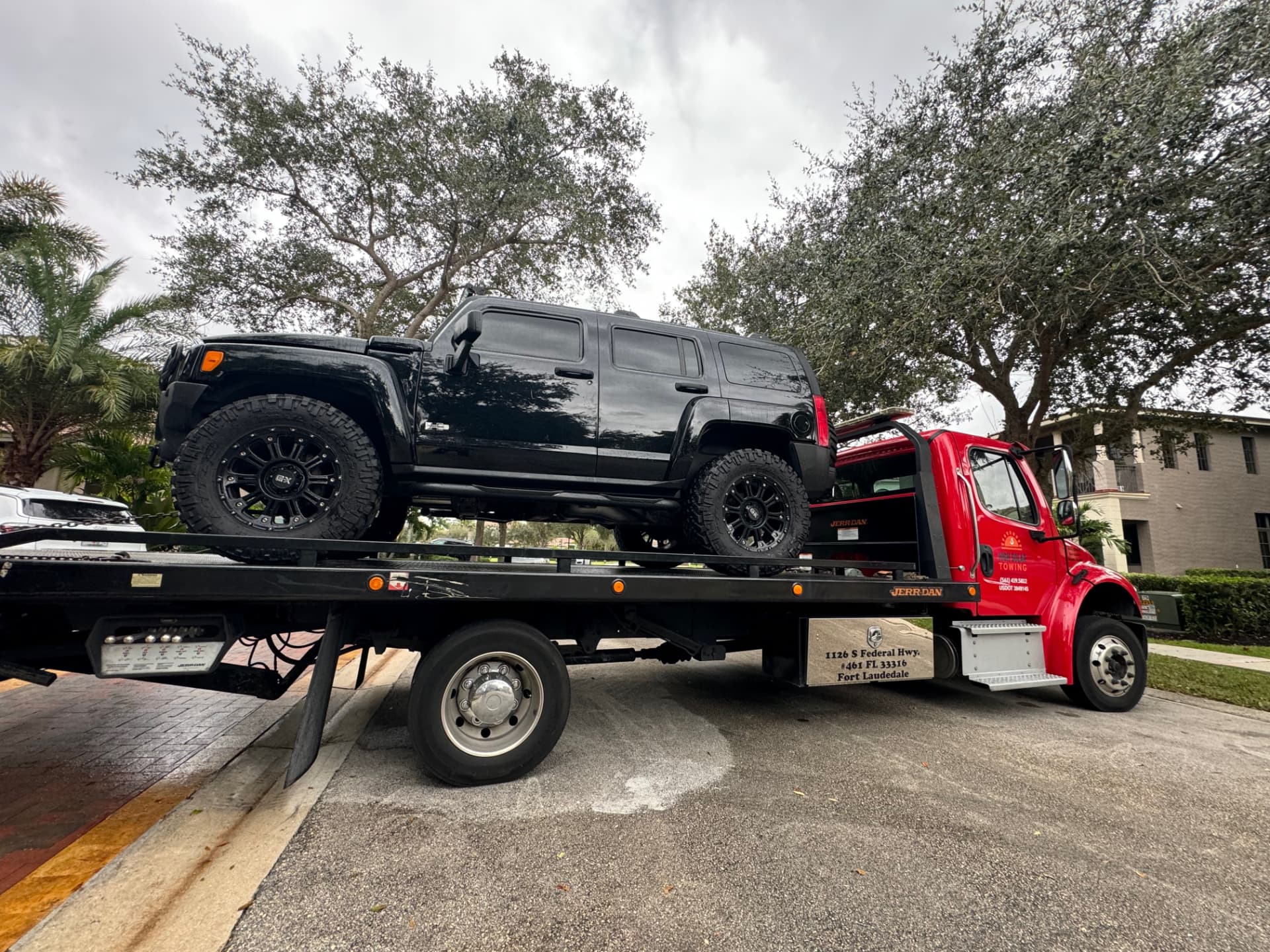 High Solar Towing flatbed carrying an SUV in Delray Beach, FL
